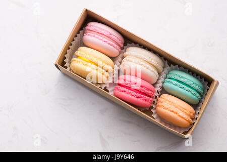 Macarons sucrés. Les cookies français différents macarons dans une boîte de papier. Banque D'Images