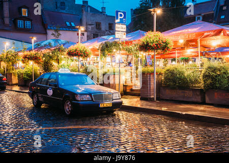 Riga, Lettonie - Juillet 3, 2016 : Taxi Voiture Mercedes-Benz W140 Clients attendre près de Open Air Lieu de loisirs centre de loisirs Egle en soirée ou la nuit Illuminat Banque D'Images