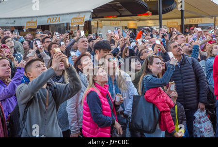 Foule de gens à l'écoute et de tournage sur leur smartphone Banque D'Images