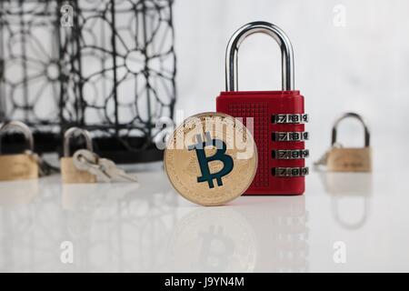 La monnaie numérique or physique de monnaie bitcoin cadenas numérique rouge proche. Banque D'Images