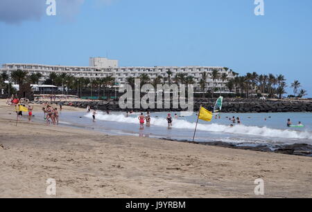 Drapeaux jaunes indiquant un sauveteur en service sur Playa las Cucharas, Costa Teguise, Lanzarote, Espagne Banque D'Images