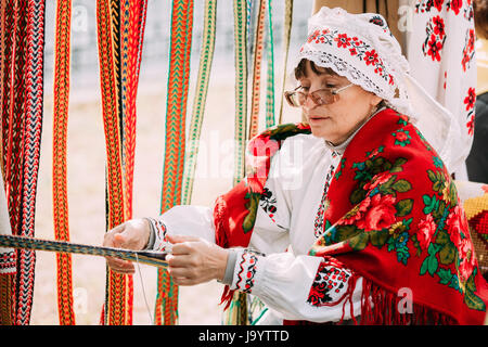 Gomel, Bélarus - 12 septembre 2015 : Femme en costume folklorique biélorusse national ceinture tissage Banque D'Images