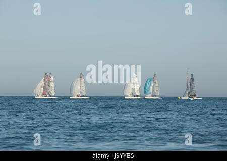 Groupe de préparation des bateaux à voile de race sur une soirée de printemps ensoleillée à l'entrée de Chichester harbour Hayling Island. Former une ligne ordonnée. Banque D'Images