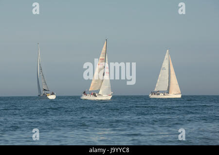 Groupe de trois bateaux à voile sur un beau soir de printemps à l'entrée de Chichester harbour Hayling Island. Banque D'Images