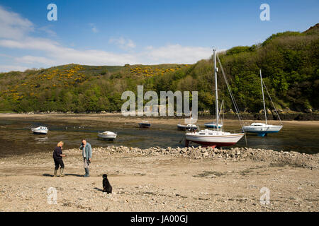 Royaume-uni, Pays de Galles, Pembrokeshire, Solva, Port, couple walking dog sur cale en face de vieux fours à chaux Banque D'Images