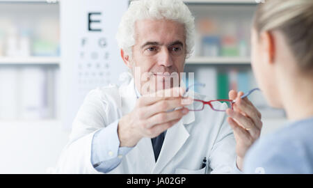 Optométriste mâle donner de nouvelles lunettes pour le patient après la visite, les soins de santé et soins de la vue concept Banque D'Images