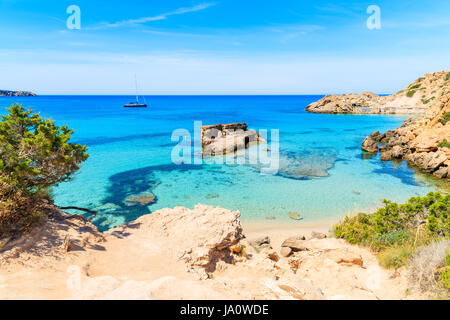 Vue sur la baie de Cala Tarida avec rochers dans l'eau de mer turquoise, l'île d'Ibiza, Espagne Banque D'Images