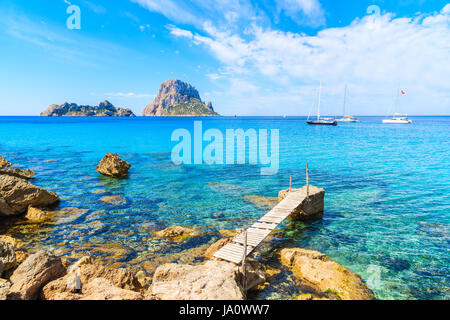 Petite jetée en bois dans la baie de Cala d'Hort et vue sur Es Vedra île, l'île d'Ibiza, Espagne Banque D'Images