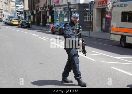 London UK. 4 juin 2017 officier de police armés au périmètre cordon, après la nuit dernière, l'attaque terroriste de Londres. Theresa May a quitté le sentier de la campagne électorale de tenir une réunion du comité d'intervention d'urgence, Cobra, ce matin à la suite d'une attaque terroriste dans le centre de Londres dans la nuit de samedi. 7 personnes ont été tuées et au moins 48 blessés dans des attaques terroristes sur London Bridge et Borough Market. Banque D'Images