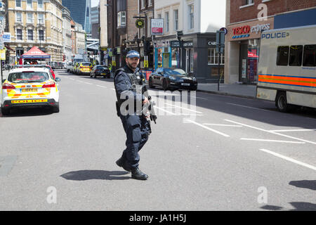 London UK. 4 juin 2017 officier de police armés au périmètre cordon, après la nuit dernière, l'attaque terroriste de Londres. Theresa May a quitté le sentier de la campagne électorale de tenir une réunion du comité d'intervention d'urgence, Cobra, ce matin à la suite d'une attaque terroriste dans le centre de Londres dans la nuit de samedi. 7 personnes ont été tuées et au moins 48 blessés dans des attaques terroristes sur London Bridge et Borough Market. Banque D'Images