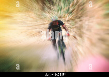 Flou de sport. Cycliste Vtt équitation seule piste cycliste et de faire du vélo sur une route pour le coucher du soleil Banque D'Images
