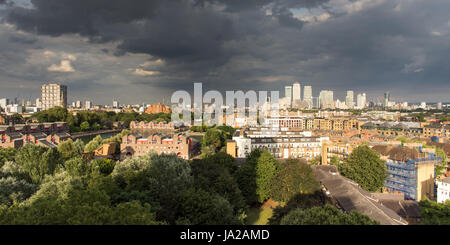 Londres, Angleterre, Royaume-Uni - 5 août 2016 : Gratte-ciel du quartier des Docklands de Londres sont éclairés contre les nuages de tempête. Banque D'Images