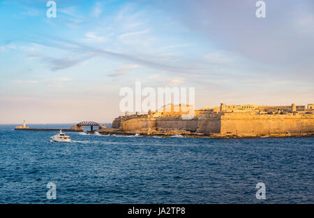 Fort Saint Elmo et brise-lames avec le phare au coucher du soleil, La Valette, Malte Banque D'Images