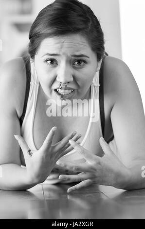 Belle femme du nez, la femme est le saignement de son nez sur le plancher en bois, l'effet noir et blanc Banque D'Images