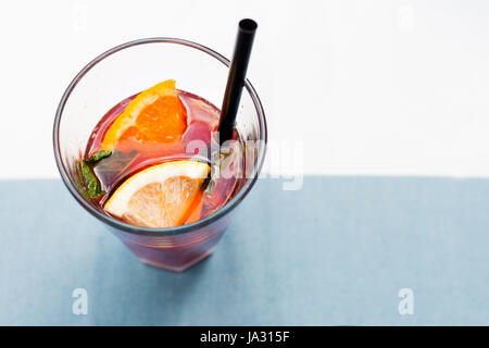 Cocktail limonade rouge vif avec la framboise garnir de citron, de baies et de menthe sur la table Banque D'Images