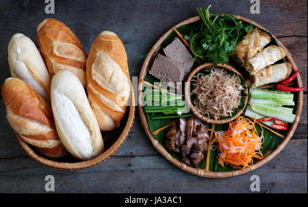 La nourriture vietnamienne est célèbre banh mi thit, aliments de rue populaire de pain farci de matière première : porc, jambon, pâté, oeuf, oignons verts, carottes, concombre.. Banque D'Images