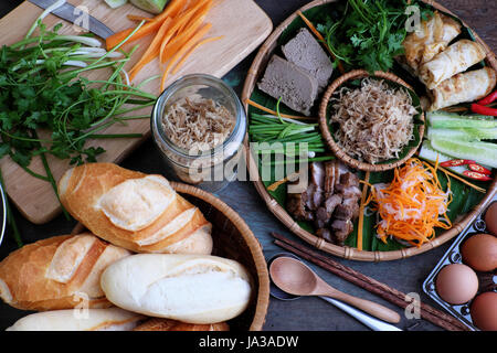 La nourriture vietnamienne est célèbre banh mi thit, aliments de rue populaire de pain farci de matière première : porc, jambon, pâté, oeuf, oignons verts, carottes, concombre.. Banque D'Images