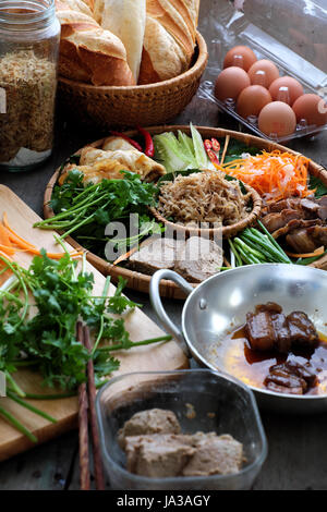La nourriture vietnamienne est célèbre banh mi thit, aliments de rue populaire de pain farci de matière première : porc, jambon, pâté, oeuf, oignons verts, carottes, concombre.. Banque D'Images