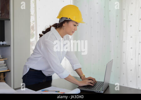 Les femmes asiatiques à l'aide d'ingénierie pour l'ordinateur portable au bureau de travail Banque D'Images