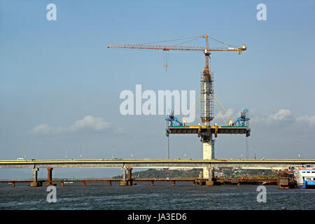 Étapes de la construction du pont de pont à haubans de chaque côté d'un grand pilier de béton à l'aide de grue a tour, construit en travers de la rivière Mandovi, Goa. Banque D'Images