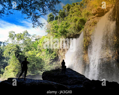 Traveler standing at cascade dans Forêt profonde au parc national Khao Yai, Thaïlande Banque D'Images