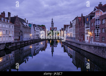 Jan van Eyckplein, vieille ville de Bruges, Belgique pendant le coucher du soleil avec la réflexion sur l'eau. Banque D'Images