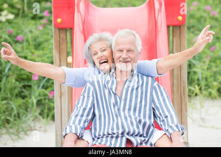 Senior couple on children's slide Banque D'Images