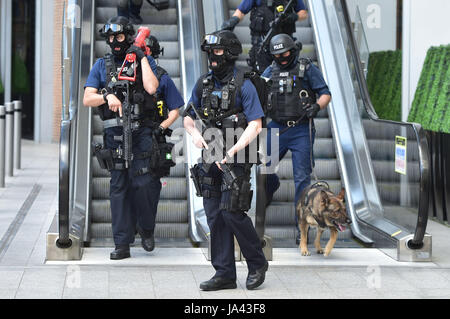 La police armée descendre un escalator au pied du tesson à l'extérieur de la station London Bridge, près de la scène de la nuit dernière, l'incident terroriste. Banque D'Images