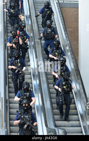 La police armée descendre un escalator au pied du tesson à l'extérieur de la station London Bridge, près de la scène de la nuit dernière, l'incident terroriste. Banque D'Images