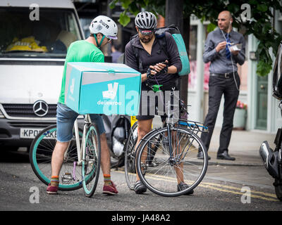 Deliveroo Bike Couriers chat livraison de nourriture et de comparer des emplois dans le centre de Londres Banque D'Images