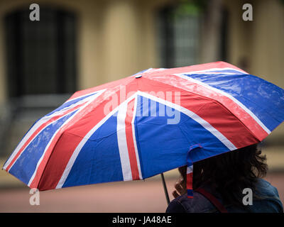 Un touriste porte un parapluie Union Jack au cours d'une douche à effet pluie dans le centre de Londres, UK Banque D'Images