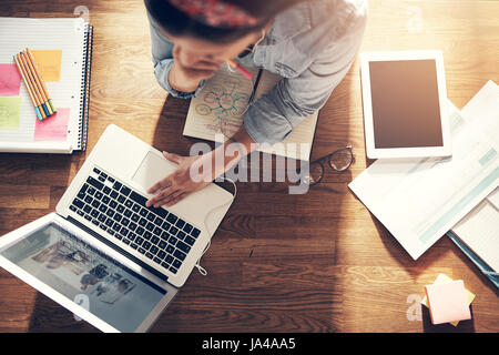 Au-dessus de la femme entrepreneur et ordinateur portable navigation holding pencil en pensant au laptop in office. Banque D'Images