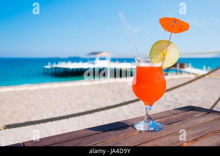 Cocktail Orange avec apple pièce sur table en bois. Journée ensoleillée près de la mer méditerranée. L'heure d'été Banque D'Images
