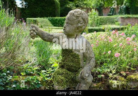 Chérubin pierre holding grapes en jardin anglais, Norfolk, Angleterre Banque D'Images