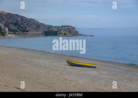 Bateau bleu et jaune dans une plage méditerranéenne de la mer Ionienne - Bova Marina, Calabre, Italie Banque D'Images