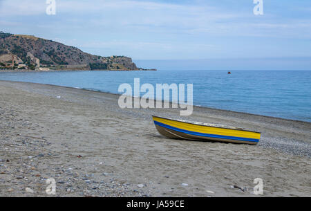 Bateau bleu et jaune dans une plage méditerranéenne de la mer Ionienne - Bova Marina, Calabre, Italie Banque D'Images