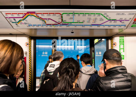 Vue horizontale de passagers à l'intérieur de l'EXAMEN À MI-PARCOURS, Mass Transit Railway, à Hong Kong, Chine. Banque D'Images