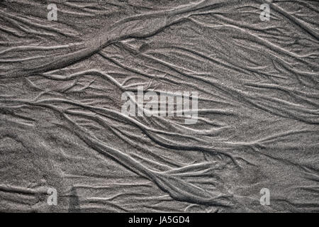 La texture du sable de mer humide avec des traces d'eau macro Banque D'Images