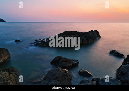 Des pierres sur la plage d'actualité au beau coucher du soleil. Nature fond Banque D'Images