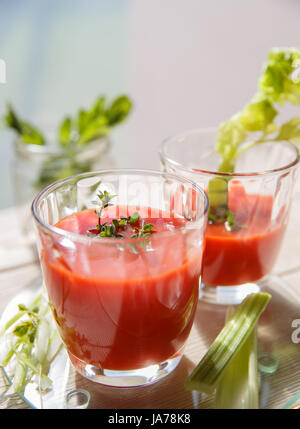 Deux verres de jus de tomates fraîches avec le thym et le céleri. Banque D'Images