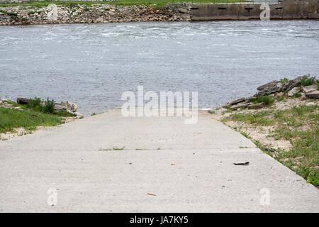 Rampe de mise à l'eau du ciment menant à la rivière. Banque D'Images