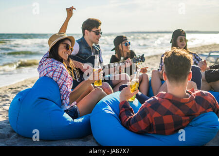 Groupe d'amis de boire sur la plage partie Banque D'Images