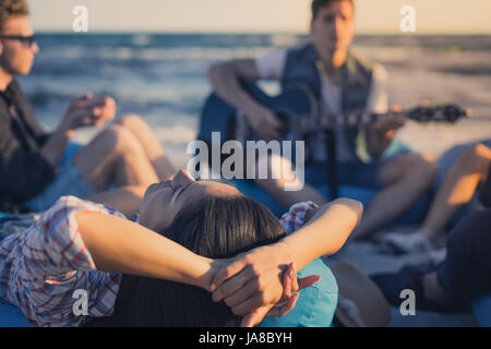 Groupe d'amis avec de la guitare et de l'alcool sur la plage partie Banque D'Images