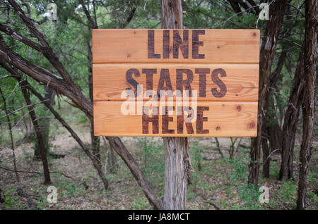 Un panneau en bois qui dit, 'Ligne commence ici." dans Wimberley, Texas Banque D'Images