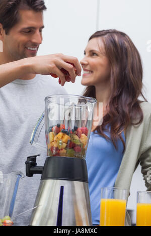 Man putting divers fruits dans blender Banque D'Images