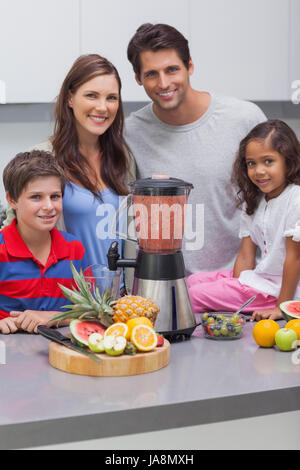 Smiling family à l'aide d'un mixeur, ensemble dans la cuisine Banque D'Images