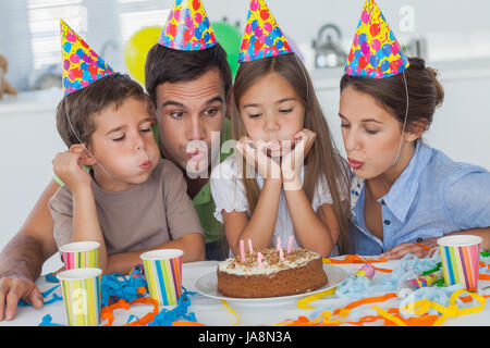 Family blowing candles ensemble tout en célébrant un anniversaire Banque D'Images