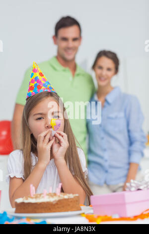 Little girl Playing with a party horn lors de son anniversaire Banque D'Images