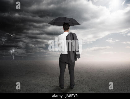 Portrait d'un parapluie et d'une veste par-dessus son épaule face à une tempête Banque D'Images