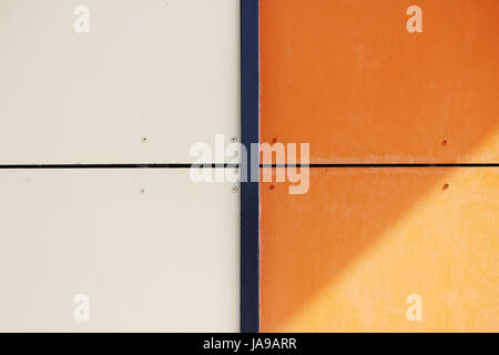 Le mur de la maison, garnie de panneaux colorés, peints dans des couleurs vives. Orange et beige. Banque D'Images